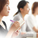 説明会を聞いている女性