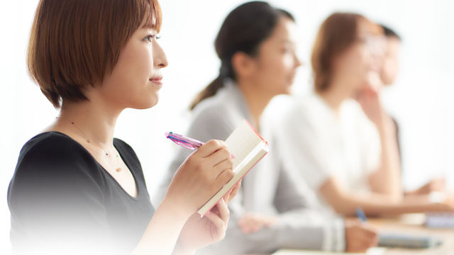 説明会を聞いている女性